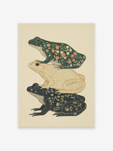 Illustrative art print showing three stacked frogs with floral patterns in dark green, tan, and indigo colors on a light background.
