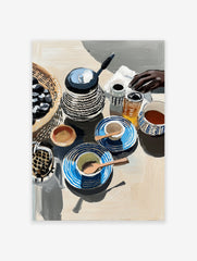 Still life poster of a breakfast table with a kettle, patterned blue cups, a basket of olives, and a hand reaching.