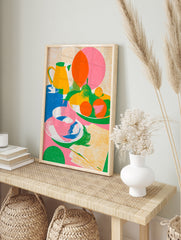 Colourful still life illustration with a yellow jug, bowl of fruit, and tea cup, featuring a, in an alternate framed mockup