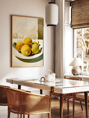 Painterly still life of yellow lemons with green leaves on a white plate against a light textured, in a styled room mockup