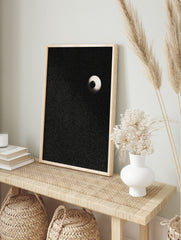 Stippled eyeball art print with a black pupil and light sclera on a speckled black, in an alternate framed mockup