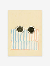 Striped beach towel poster with round black sunglasses on blue and pink stripes
