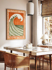Stylised green and white ocean wave against burnt orange background, within ornate scrollwork border, in a styled room mockup