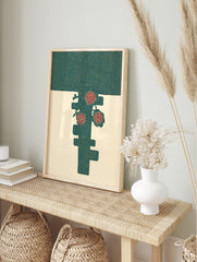 Stylised red flowers and leaves on a dark teal abstract shape against a cream background, in an alternate framed mockup