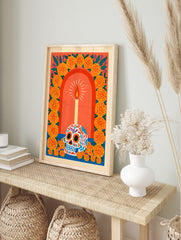 Sugar skull illustration with lit candle and marigold flower arch on orange background, in an alternate framed mockup