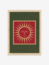 Illustrative red sun face wall art print with tan and green borders on a cream background