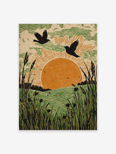 Linocut-style art print of two birds flying over an orange sun, green fields, and tall foreground grass