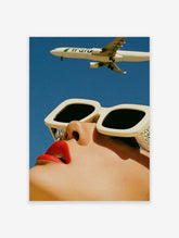 Surreal fashion poster of a face with red lips and cream sunglasses, plane flying above in a blue sky