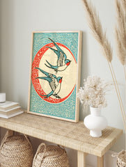 Vintage illustrative art print of two swallow birds flying inside a decorative circular frame, in an alternate framed mockup