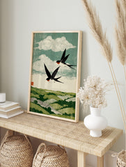 Woodblock style print of two black and white swallows with red throats flying over green, in an alternate framed mockup