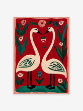 Illustrative print of two white swans forming a heart, with a wine glass, pink and blue flowers on red background