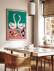 Illustrative print of two white swans forming a heart above a pink tablecloth with wine, cheese, in a styled room mockup