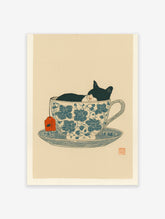 Black and white cat sleeping in a blue floral teacup with an orange tea tag, whimsical illustration print.