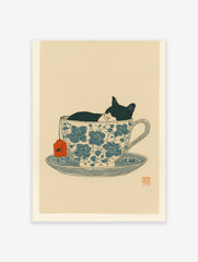 Black and white cat sleeping in a blue floral teacup with an orange tea tag, whimsical illustration print.