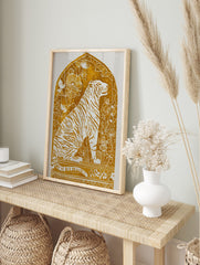 Illustrative golden tiger art print with white stripes and botanical details within an arched, in an alternate framed mockup