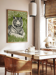 Linocut-style tiger wall art print with green eyes, black stripes, and white fur, against a green, in a styled room mockup