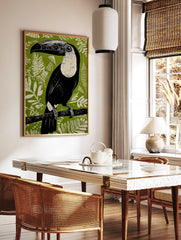 Black and white Toucana toucan linocut art print on a vibrant green jungle foliage background, in a styled room mockup
