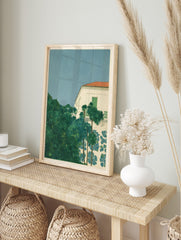 Tropical villa with white walls, red roof, green shutters, lush palm trees, and blue floral, in an alternate framed mockup