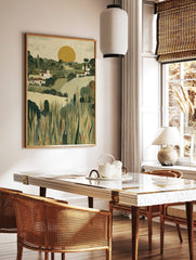 Illustrative Tuscan landscape art print with white houses, green hills, golden wheat fields, and a, in a styled room mockup