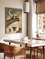 Vintage illustration of two cats sitting on a roof under a crescent moon, paper wall art print, in a styled room mockup