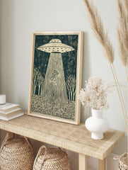 Linocut-style print of a striped tiger being abducted by a UFO's tractor beam, set in a forest, in an alternate framed mockup