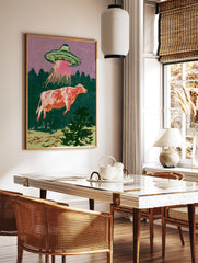 Retro illustration of a UFO abducting a cow with a pink tractor beam against a purple sky and green, in a styled room mockup