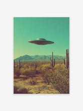 Retro UFO wall art print featuring a flying saucer hovering over a desert landscape with cacti and mountains under a teal sky.