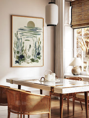 Underwater diver art print in watercolour style with green and blue marine plants and a muted sun, in a styled room mockup