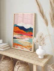 Abstract mountain landscape art print with pink sky, orange hills, blue mountains, and white, in an alternate framed mockup