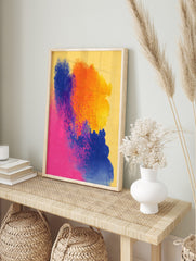 Abstract art print with vibrant blue, orange, and pink powder splashes on a yellow, in an alternate framed mockup