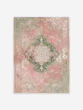 Distressed pink and green vintage area rug with ornate medallion and floral Persian-style pattern on a white background