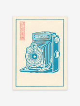 Blue vintage folding camera illustration art print with a red Japanese seal on a cream background within a blue border.