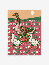 Vintage-style goose and two goslings walking across a pink floral patterned background with green hills and a pale sun