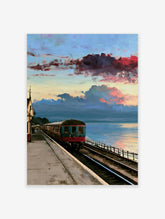 Vintage train carriage at a coastal railway station under a dramatic red and blue sunset sky