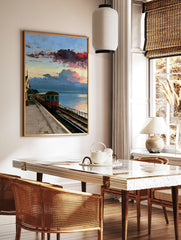 Vintage train carriage at a coastal railway station under a dramatic red and blue sunset sky, in a styled room mockup