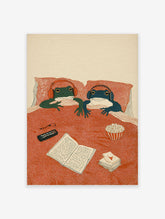 Illustrated frog art print of two frogs in bed with headphones, remote, book, and popcorn, enjoying a cozy night in.