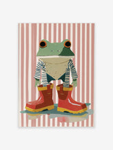 Whimsical frog wall art wearing a striped shirt and red rain boots against a pink and white striped background.