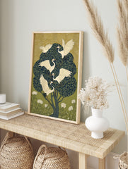 Illustrative art print of five white egrets with leafy branches in a dark green tree, with, in an alternate framed mockup
