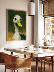 Quirky wide-eyed duck illustration with a yellow bill against a dark green background, art print, in a styled room mockup