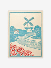 Illustrative windmill landscape art print with a bridge, cottage, and red flowers in a blue and white colour palette