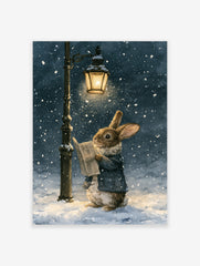 Watercolor illustration of a brown rabbit in a blue coat reading a newspaper under a lit streetlamp during a snowfall