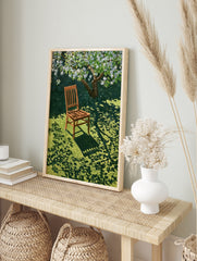 Wooden chair resting on green grass under a blooming white tree, casting dappled shadows on, in an alternate framed mockup
