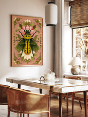 Ornate yellow beetle illustration with green wings and black spots, surrounded by pink and white, in a styled room mockup