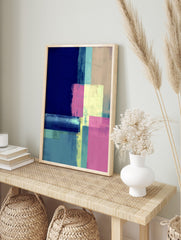 Abstract geometric wall art with layered blocks in navy, aqua, pale yellow, and pink, in an alternate framed mockup