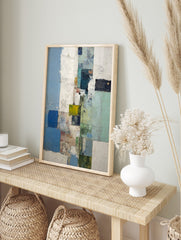 Abstract blocks wall art with textured blue, green, white, and yellow rectangular shapes in a, in an alternate framed mockup