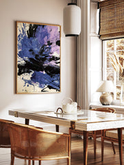 Abstract art print with dynamic blue, purple, and black paint splatters and strokes on a white, in a styled room mockup