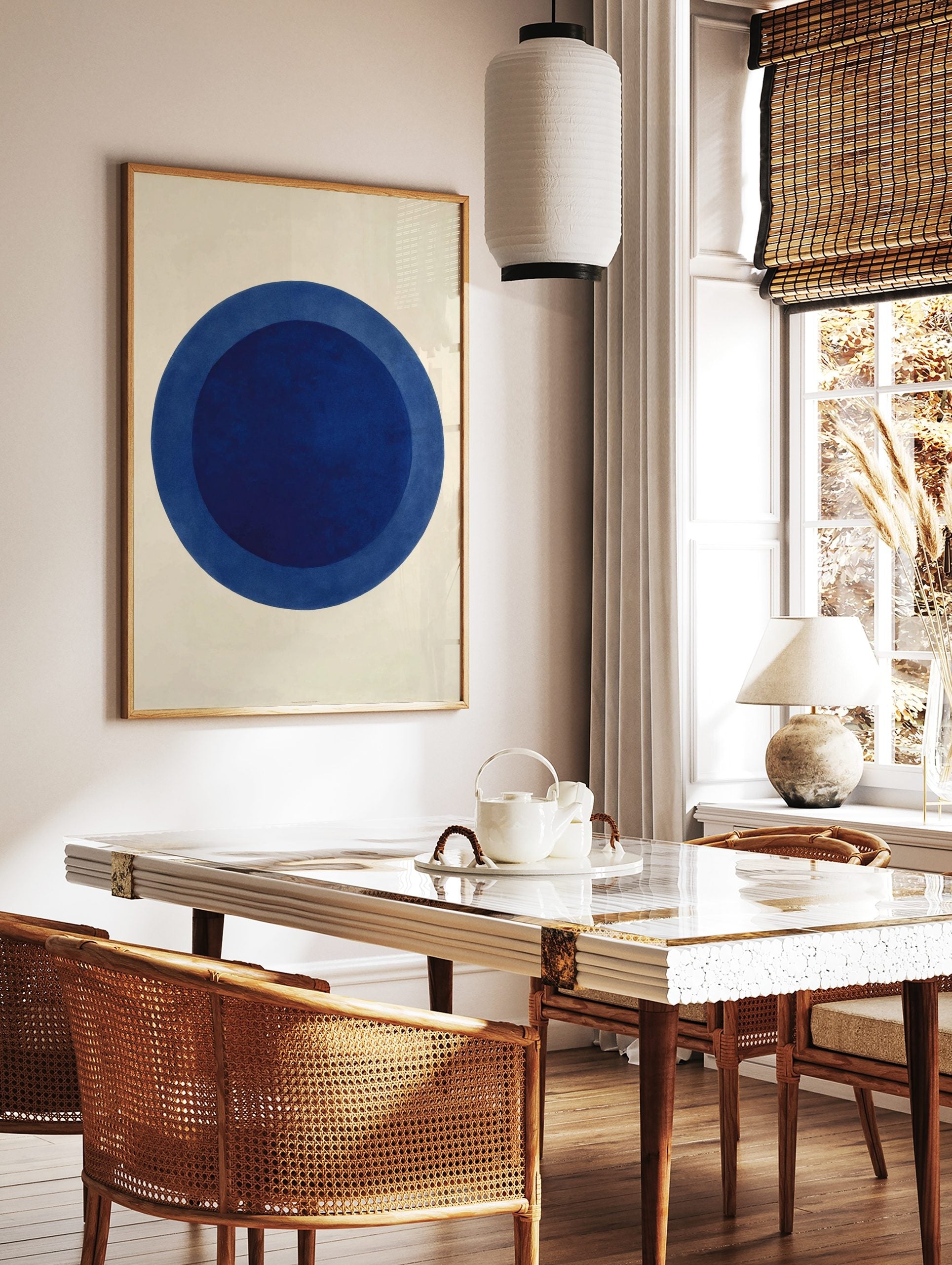 Minimalist abstract art print with two concentric blue circles on a white background, in a styled room mockup