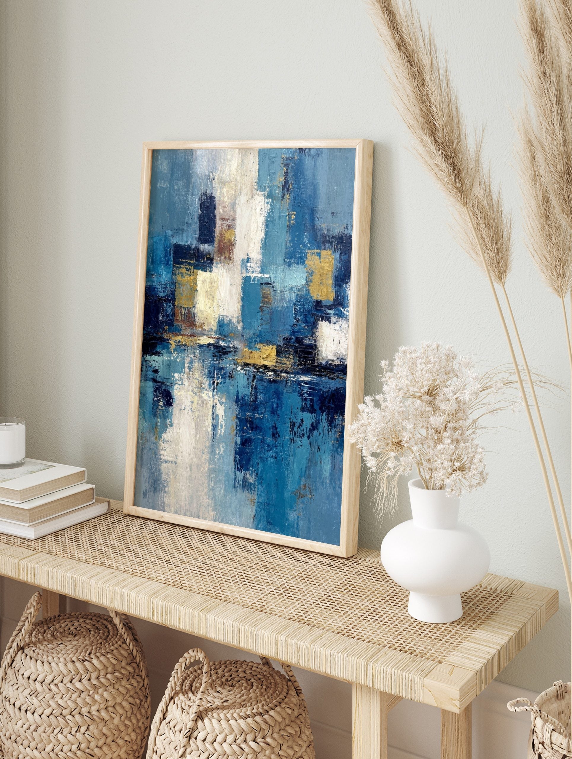 Abstract blue, white, and gold textured painting with layered blocks of colour and a, in an alternate framed mockup