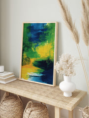 Abstract art print with bold, sweeping brushstrokes in green, blue, and yellow colours, in an alternate framed mockup