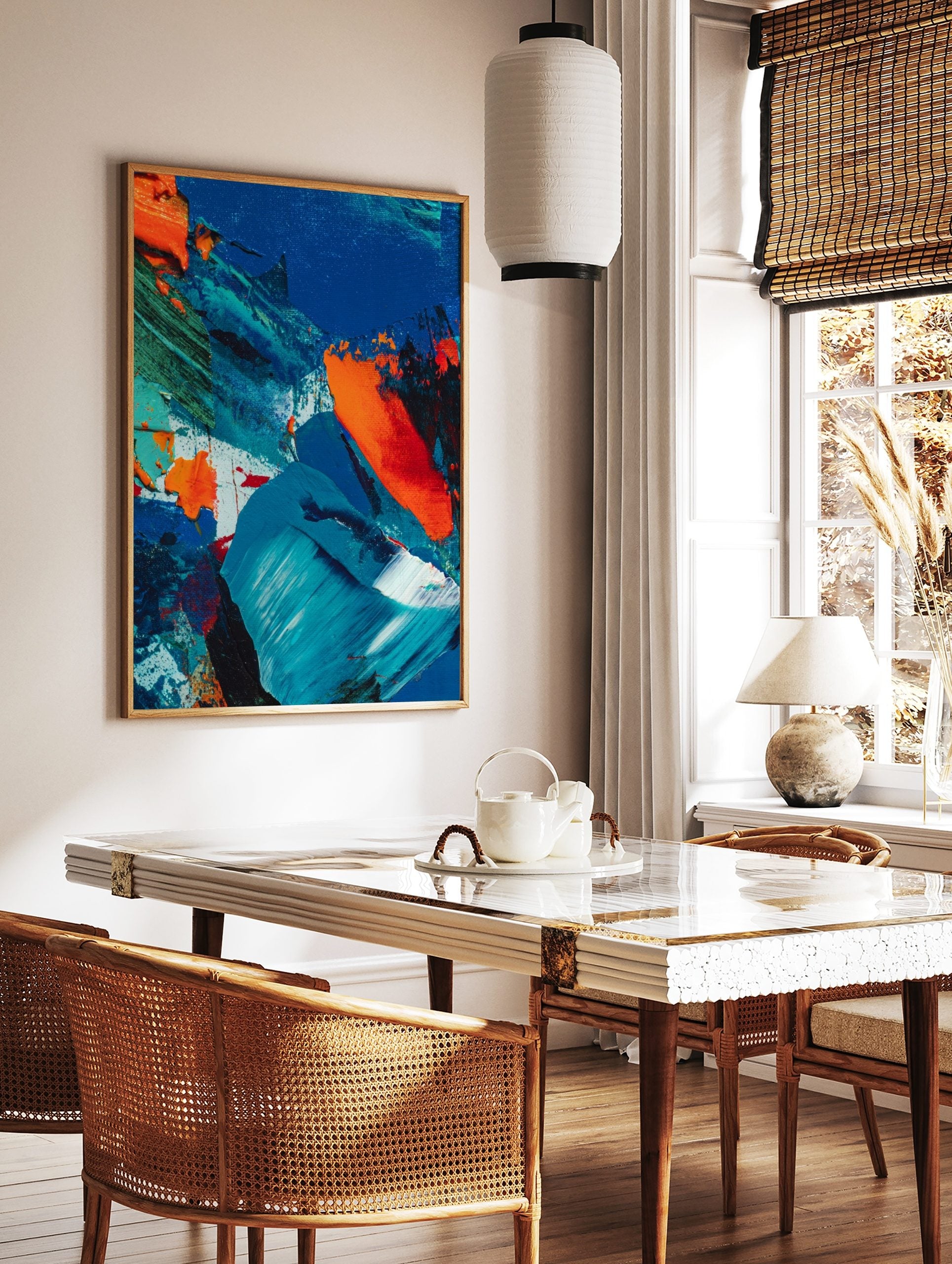 Abstract painting with textured blue, orange, and green impasto brushstrokes on canvas, in a styled room mockup